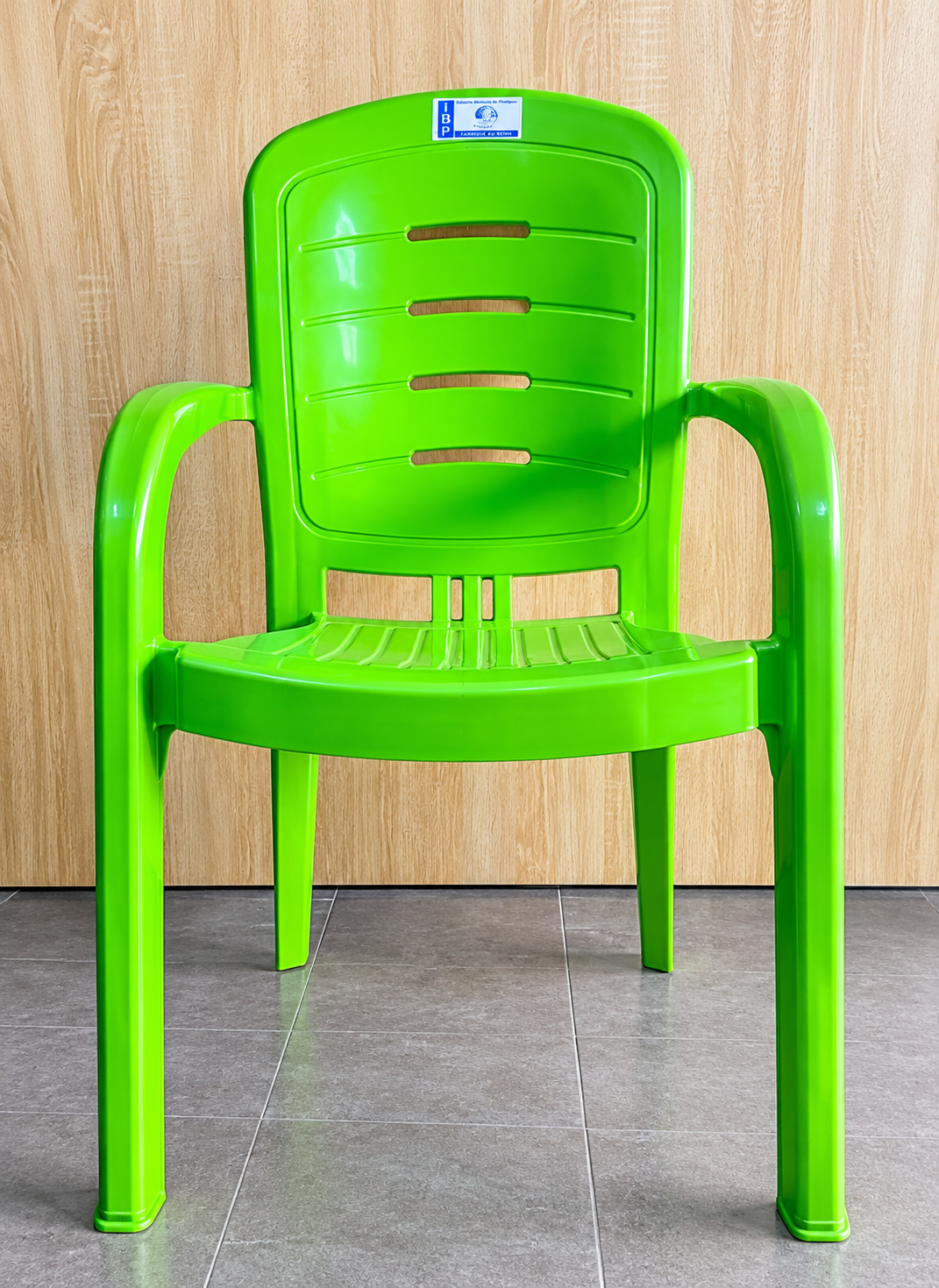 Chaise en plastique vert, grand format, avec accoudoirs et dossier à lamelles, fabriquée au Bénin par IBP
