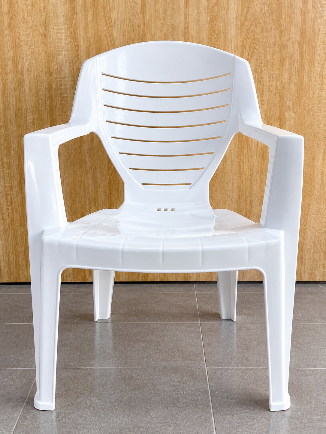 Chaise en plastique blanche petit format, avec accoudoirs et dossier à lamelles, fabriquée au Bénin par IBP